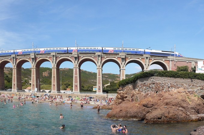 Trem passa por cima de ponte dos arcos em praia de Côte D’ Azur, no sul da França