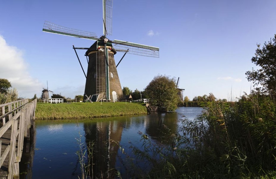 Os moinhos de <a href="https://viajeaqui.abril.com.br/estabelecimentos/holanda-amsterda-atracao-moinhos-em-kinderdijk" rel="Kinderdijk" target="_blank">Kinderdijk</a>, a 95 quilômetros de Amsterdã, cuja função principal e fundamental é bombear a água de represas e canais, são hoje patrimônio da humanidade