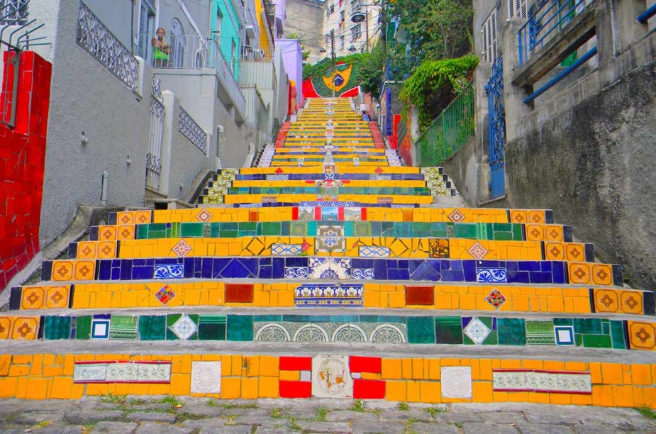 <strong>5. <a href="https://viajeaqui.abril.com.br/estabelecimentos/br-rj-rio-de-janeiro-atracao-escadaria-selaron" target="_blank" rel="noopener">Escadaria Selarón</a>, Lapa, <a href="https://viajeaqui.abril.com.br/cidades/br-rj-rio-de-janeiro" target="_blank" rel="noopener">Rio de Janeiro</a></strong> Entre as atrações do bairro boêmio da Lapa, na região central do Rio, está essa escadaria assinada pelo artista chileno Jorge Selarón, que liga a Rua Joaquim Silva à Ladeira de Santa Teresa. O destino do pintor e ceramista, responsável pela junção harmônica do conjunto vivo de azulejos, foi trágico: em 2013, seu corpo foi encontrado carbonizado na própria escadaria que leva o seu nome, próximo à casa na qual viveu por mais de trinta anos. Sua obra, felizmente, virou um dos pontos mais alegres e cheios de vida da cidade