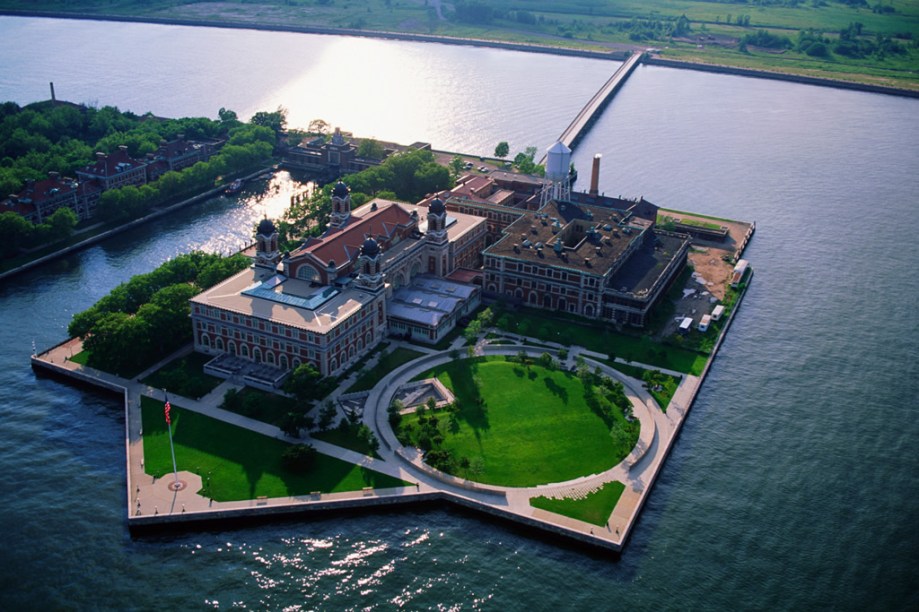 Por <a href="https://viajeaqui.abril.com.br/estabelecimentos/estados-unidos-nova-york-atracao-estatua-da-liberdade-e-ellis-island" rel="Ellis Island" target="_blank">Ellis Island</a> dezenas de milhares de imigrantes entraram nos Estados Unidos. Hoje o complexo abriga o Museu da Imigração - além, é claro, da Estátua da Liberdade