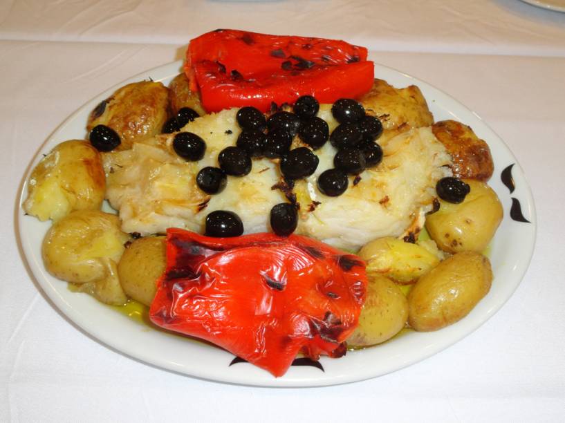 Bacalhau do Maraca, do <a href="https://viajeaqui.abril.com.br/estabelecimentos/br-rj-rio-de-janeiro-restaurante-adegao-portugues" rel="Adegão Português" target="_blank"><strong>Adegão Português</strong></a> de <strong>São Cristovão</strong>, no <a href="https://viajeaqui.abril.com.br/cidades/br-rj-rio-de-janeiro" rel="Rio" target="_blank"><strong>Rio</strong></a>. Na foto, bacalhau e pimentões assados na brasa, batatas ao murro e molho de azeitonas sem caroço sobre a posta, finalizado com alho frito laminado. <em>Rua Campo S. Cristóvão, 212 (S. Cristóvão). Tel. (21) 2580-7288 </em>