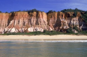 A Praia da Pitinga é versátil, no canto esquerdo ficam as barracas que garantem o movimento, do outro lado, as falésias dominam o cenário, deserto e com mar calmo