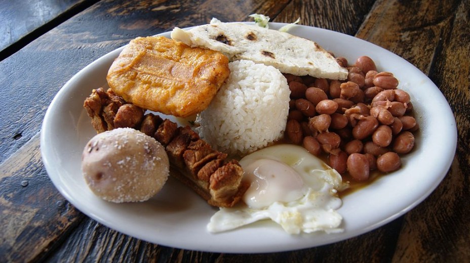 <strong>Bandeja Paisa, <a href="https://viajeaqui.abril.com.br/paises/colombia" rel="Colombia" target="_blank">Colombia</a></strong>        Se algum dia um mineiro subiu os Andes colombianos, foi ele o inventor da <em>bandeja paisa</em>. Uma mastodôntica combinação de diversos pratos chega à mesa para felicidade dos glutões e desespero (ou alegria, sei lá) das fofinhas. Vale tudo: arroz, feijão, ovo, carne moída, linguiça, torresmo, um bolinho chamado arepa e muito mais. Triglicérides, cheguei!