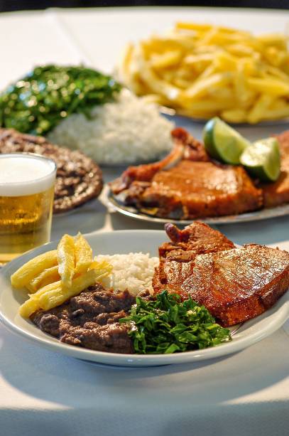 <strong>PARA CURTIR O CENTRO E ARREDORES</strong> <strong><a href="https://pt-br.facebook.com/barbrasil.alemaodalapa/" target="_blank" rel="noopener">Bar Brasil</a> </strong>A cozinha germânica é um traço em comum no cardápio de alguns endereços centenários do <a href="https://viajeaqui.abril.com.br/cidades/br-rj-rio-de-janeiro" target="_blank" rel="noopener">Rio</a>. É o caso do <a href="https://viajeaqui.abril.com.br/estabelecimentos/br-rj-rio-de-janeiro-restaurante-bar-luiz" target="_blank" rel="noopener">Bar Luiz</a> e também do Bar Brasil – aberto em 1907 com o nome de Bar Zeppelin e rebatizado na época da Segunda Guerra Mundial. Receitas vigorosas, como kassler (costela suína defumada) e eisbein (joelho de porco), vão à mesa na companhia de salada de batata, chucrute e do chope cremoso. O sobrado tem portas e biombos de madeira escura e duas entradas, uma pela Mem de Sá e outra pela Rua do Lavradio, que reúne antiquários e é opção para um passeio depois do almoço. A poucos metros fica o Nova Capela (R. Mem de Sá, 96), célebre pelo cabrito com alho frito e arroz de brócolis <em>Av. Mem de Sá, 90 (Lapa), (21) 2509-5943</em>