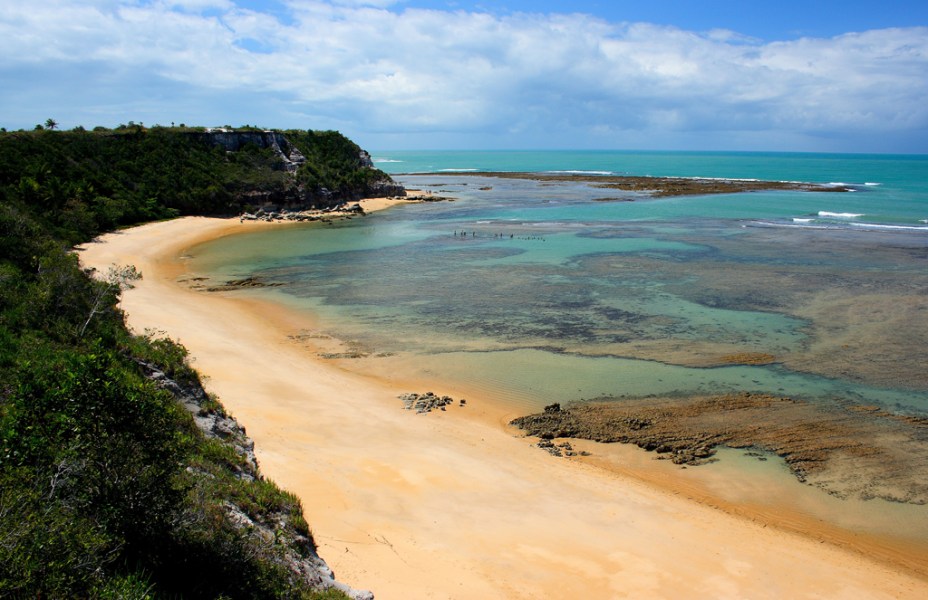 <strong>13. <a href="https://viajeaqui.abril.com.br/cidades/br-ba-praia-do-espelho" target="_blank" rel="noopener">Praia do Espelho (BA)</a></strong>Considerada por muitos especialistas uma das praias mais bonitas do Brasil, a Praia do Espelho encanta pela variação de cores de suas águas cristalinas nos dias ensolarados, que podem ser admiradas da areia ou, melhor, do alto das falésias.Na maré baixa, piscinas naturais se revelam – prepare o snorkel. Toda essa beleza é preservada por causa do acesso ao local, que não é muito fácil. Quem vai de carro, precisa encarar 20 quilômetros de estrada de terra, que pode ficar intransitável em dias de chuva.<em> <a href="https://www.booking.com/searchresults.pt-br.html?aid=332455&lang=pt-br&sid=eedbe6de09e709d664615ac6f1b39a5d&sb=1&src=index&src_elem=sb&error_url=https%3A%2F%2Fwww.booking.com%2Findex.pt-br.html%3Faid%3D332455%3Bsid%3Deedbe6de09e709d664615ac6f1b39a5d%3Bsb_price_type%3Dtotal%26%3B&ss=Praia+do+Espelho%2C+%E2%80%8BBahia%2C+%E2%80%8BBrasil&checkin_monthday=&checkin_month=&checkin_year=&checkout_monthday=&checkout_month=&checkout_year=&no_rooms=1&group_adults=2&group_children=0&from_sf=1&ss_raw=Praia+do+Espelho+&ac_position=0&ac_langcode=xb&dest_id=900050228&dest_type=city&search_pageview_id=c1bb81afaa570238&search_selected=true&search_pageview_id=c1bb81afaa570238&ac_suggestion_list_length=5&ac_suggestion_theme_list_length=0&district_sel=0&airport_sel=0&landmark_sel=0" target="_blank" rel="noopener">Busque hospedagens na Praia do Espelho no Booking.com </a></em>