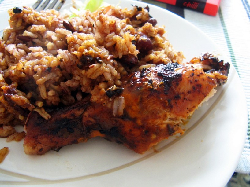 <strong>Jerk Chicken, <a href="https://viajeaqui.abril.com.br/paises/jamaica" rel="Jamaica" target="_blank">Jamaica</a></strong><br />              Não é o prato mais bonito do mundo: pedaços de frango vêm chamuscados, meio trucidados, acompanhados por uma gororoba de arroz meio sem-vergonha. Mas não se engane, esta é uma das comidas de rua mais suculentas do <a href="https://viajeaqui.abril.com.br/continentes/america-central" rel="Caribe" target="_blank"><strong>Caribe</strong></a>. Acompanhada de uma cerveja Red Stripes, ouvindo um bom Bob Marley e vendo o pôr-do-sol em <a href="https://viajeaqui.abril.com.br/cidades/jamaica-negril" rel="Negril" target="_blank">Negril</a>, é o sonho de verão. Existem versões feitas com carne de boi e porco. 