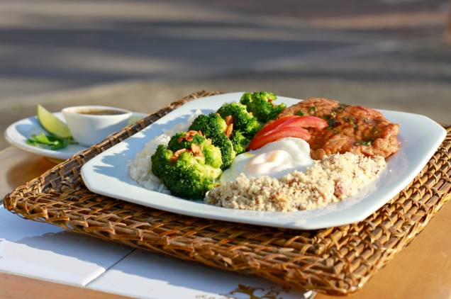 Prato no Luigi inclui arroz branco, farofa de cebola e bacon, travesseiros de bisteca e brócolis com alho e ovo frito Prato no Luigi inclui arroz branco, farofa de cebola e bacon, travesseiros de bisteca e brócolis com alho e ovo frito