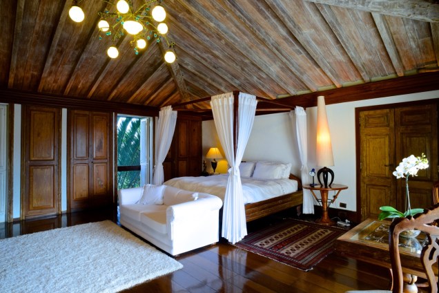 Dos 6 quartos, 5 são suítes – acima, a cama com dossel, o assoalho e o teto de madeira patinada dão certa sofisticação Dos 6 quartos, 5 são suítes – acima, a cama com dossel, o assoalho e o teto de madeira patinada dão certa sofisticação