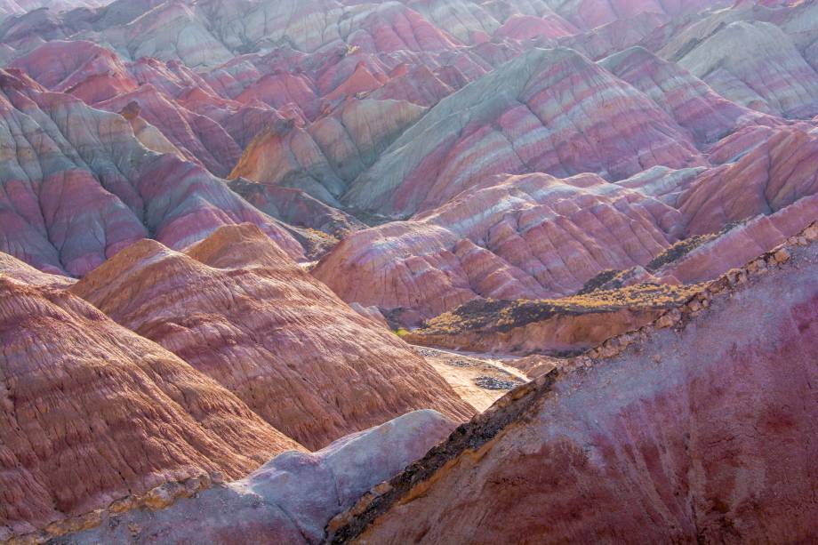<strong>Parque Geológico Nacional Zhangye Danxia, <a href="https://viajeaqui.abril.com.br/paises/china" rel="China" target="_blank">China</a></strong>Foram necessários 24 milhões de anos para esses desenhos serem formados nas montanhas do Parque Zhangye Danxia. Tal formação, ultimamente, vem chamando atenção de turistas que desejam ver as coloridas colinas que parecem ter sido pintadas à mão. O fenômeno “arco-íris” aconteceu devido a acumulação de arenito e outros minerais, que, por conta da movimentação tectônica – a mesma que deu origem ao Himalaia–, criaram diferentes camadas, cada uma com uma cor e uma textura diferente