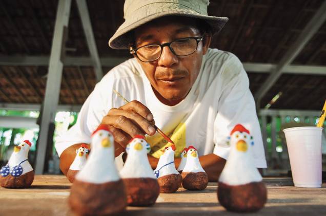 O artista plástico Carcará em seu ateliê. Símbolos do lugar, galinhas de todos os tipos enchem as vitrines do povoado O artista plástico Carcará em seu ateliê. Símbolos do lugar, galinhas de todos os tipos enchem as vitrines do povoado