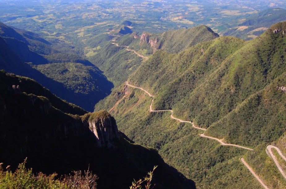 Vista assim do alto, parece um autorama radical pendurado nas montanhas. E até que é. A estrada da serra do Rio do Rastro, em Santa Catarina, tem mais de 250 curvas espetacularmente fechadas, em 8 quilômetros de um caminho estreito pra danar. As subidas enfezadas fervem os carros mais fracotes, mas recompensam quem chega lá no fm do caminho, a 1 400 metros de altitude, em Bom Jardim da Serra. Quando a neblina não aparece antes, ver o esplendor daquela montanha toda provoca até uns surtos ufanistas.