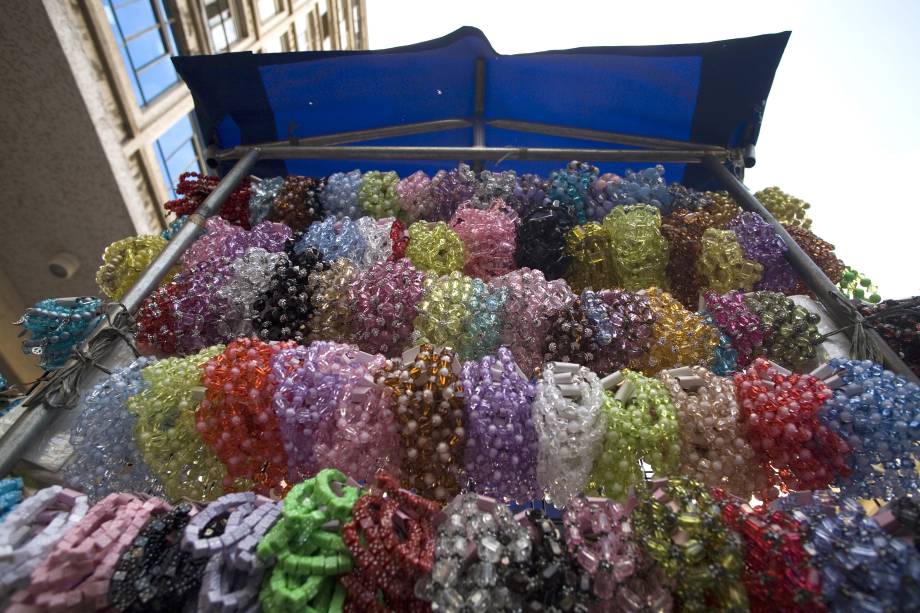 Barraca vende pulseiras plásticas na calçada da Rua 25 de Março, São Paulo