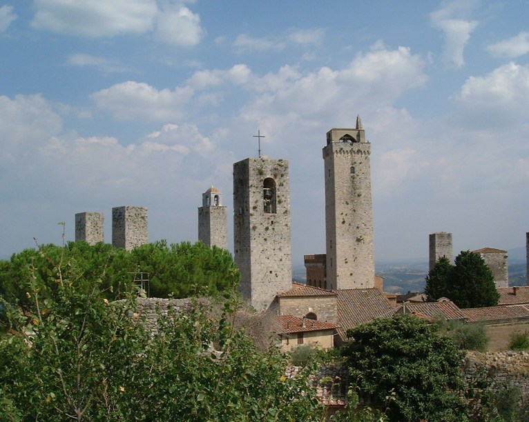 <strong>SAN GIMIGNIANO</strong> (a 20 km de Greve in Chianti)    A próxima parada é em <a href="https://viajeaqui.abril.com.br/cidades/italia-san-gimignano" rel=" San Gimigniano" target="_blank"><strong>San Gimigniano</strong></a>. A cidade das torres tem origens na antiga civilização etrusca. Alcançou um grande desenvolvimento durante a Idade Média, o que explica a grande quantidade de obras de arte que adornavam suas igrejas e conventos.    Durante esse período, as famílias patrícias que dominavam a região construíram as 74 torres que serviam para demonstrar o grau de poder de cada uma delas. Hoje restam apenas 14.    Aqui é o berço e a terra de outro famoso vinho italiano: <em>Vernaccia di San Gimigniano</em>. A produção é feita dentro dos limites de <strong>San Gimigniano</strong> e é administrada pelo <em>Consorzio della Denominazione di San Gimigniano </em>que congrega as produtoras locais.    A uva branca <em>Vernaccia</em> é encontrada em várias regiões da Itália, mas foi na Toscana onde encontrou as condições ideais para o cultivo: o clima mediterrâneo, o solo calcário e altitudes que não ultrapassam os 400 metros. Manter o respeito à tradição e possuir um dos vinhedos autóctones mais antigos da Itália, que se renovou com as modernas tecnologias sem perder a sua identidade, fez do <em>Vernaccia</em> um vinho branco único no mundo.    As vinícolas do consórcio produzem três tipos de vinho: <em>Vernaccia di San Gimignano D.O.C.G</em>., <em>San Gimignano D.O.</em>C. Rosso e <em>San Gimigniano</em> <em>D.O.C. Vin Santo</em>, nos quais a porcentagem da uva <em>vernaccia</em> é, no mínimo, 90%. O programa aqui é conhecer as vinícolas do Consórcio, para degustar e comprar os vinhos locais. Agende a sua visita acessando o <a href="https://www.vernaccia.it/aziende.aspx" rel="site da vinícola" target="_blank">site da vinícola</a>.    Conheça também Il Duomo ou Chiesa Collegiata, consagrada no ano de 1148, onde se conservam belos afrescos na Piazza del Duomo, o Palazzo Comunale, que abriga o Museu Cívico e a Pinacoteca. No mesmo local visite a Torre Grossa o del Podestá, com 54 metros de altura e o Museo Archeologico com rico acervo de peças etruscas.    Todas as informações sobre esses itinerários de arte (endereço, horários, preços) você encontra acessando o <a href="https://www.sangimignano.com/musei.htm" rel="site oficial da cidade" target="_blank">site oficial da cidade</a>. Nele, é possível agendar as visitas, caso seja necessário.