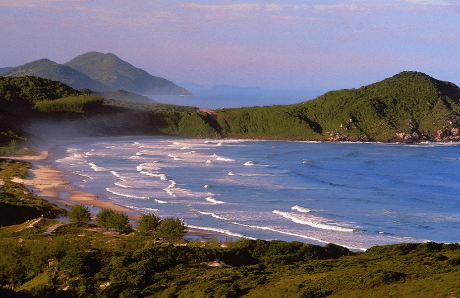 <strong>1. Praia do Rosa, Imbituba</strong> Também há trilhas pela Mata Atlântica que levam direto à areia. Sem estrutura de quiosques ou barracas, a praia impressiona pelo verde e pelos dois costões de pedra. Ao centro, a Lagoa do Meio reúne famílias em busca das águas calmas de temperatura mais amena. Jovens e surfistas concentram-se nos extremos. <a href="https://www.booking.com/searchresults.pt-br.html?aid=332455&lang=pt-br&sid=eedbe6de09e709d664615ac6f1b39a5d&sb=1&src=index&src_elem=sb&error_url=https%3A%2F%2Fwww.booking.com%2Findex.pt-br.html%3Faid%3D332455%3Bsid%3Deedbe6de09e709d664615ac6f1b39a5d%3Bsb_price_type%3Dtotal%26%3B&ss=Praia+do+Rosa%2C+Santa+Catarina%2C+Brasil&checkin_monthday=&checkin_month=&checkin_year=&checkout_monthday=&checkout_month=&checkout_year=&no_rooms=1&group_adults=2&group_children=0&from_sf=1&ss_raw=Praia+do+Rosa&ac_position=0&ac_langcode=xb&dest_id=900048708&dest_type=city&search_pageview_id=2c456d55ff360190&search_selected=true&search_pageview_id=2c456d55ff360190&ac_suggestion_list_length=5&ac_suggestion_theme_list_length=0" target="_blank" rel="noopener"><em>Busque hospedagens na Praia do Rosa no Booking.com</em></a>