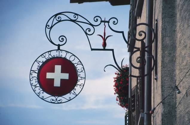 Cruz da bandeira suíça sinaliza a entrada de um café-restaurante em Genebra Cruz da bandeira suíça sinaliza a entrada de um café-restaurante em Genebra