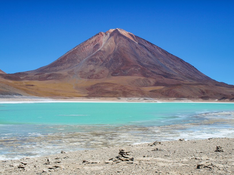 <a href="https://viajeaqui.abril.com.br/paises/bolivia" target="_blank" rel="noopener"><strong>Licancabur, Bolívia</strong></a> Localizado a 40km de <a href="https://viajeaqui.abril.com.br/cidades/chile-san-pedro-de-atacama" target="_blank" rel="noopener">San Pedro de Atacama no Chile</a>, está na fronteira entre os dois países. É ali que está o lago mais alto do mundo, dentro de seu cume de 5.913 metros de altitude. O lago tem apenas 90 x 70 metros e suas águas são mantidas a aproximadamente 6 graus, quentinho para tal altitude, graças a aquecimento geotermal que vem de dentro da terra.