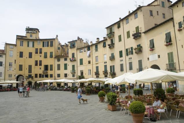 A forma ovalada da Piazza Anfiteatro, em Lucca, é emoldurada por antigos prédios de fachadas em tons pastéis e agradáveis cafés A forma ovalada da Piazza Anfiteatro, em Lucca, é emoldurada por antigos prédios de fachadas em tons pastéis e agradáveis cafés