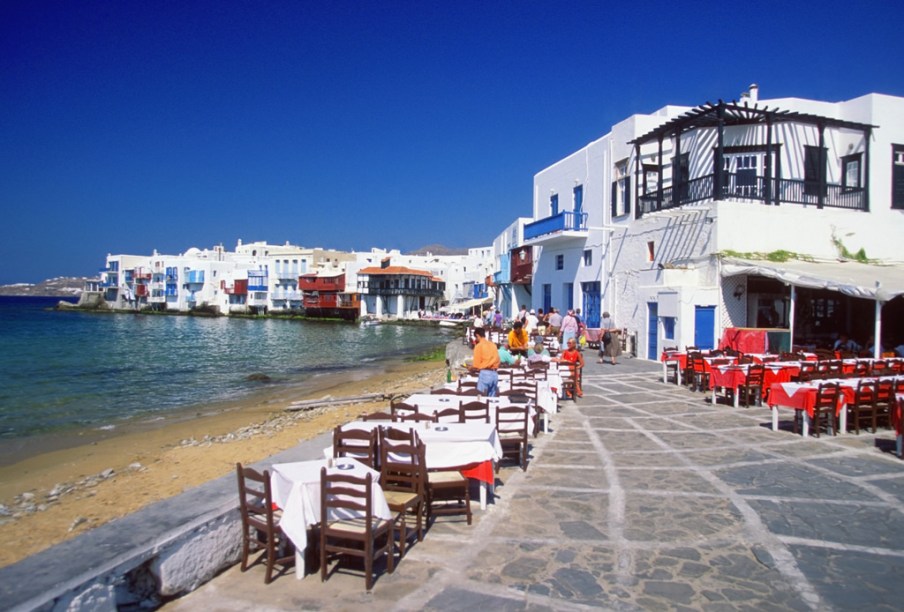 Little Venice, em Mikonos, tem um concorrido pôr do sol. Por isso, às 21 horas, turistas de todas as partes do mundo disputam vagas nos bares com vista para a baía