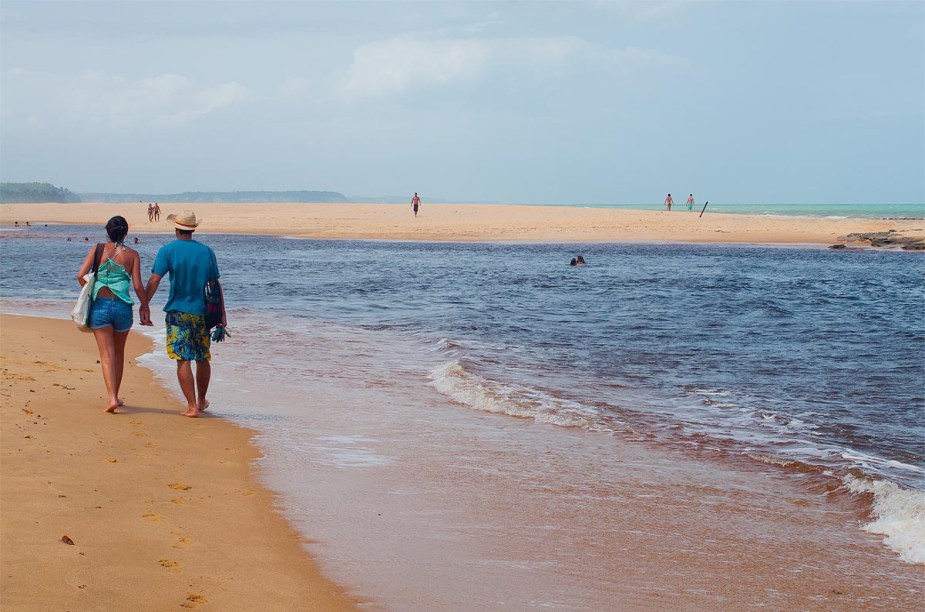 O rio deságua no mar, deixando a água mais escura