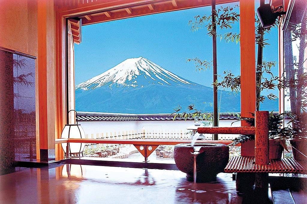 Vista para o Monte Fuji da janela de parede inteira de um banho quente (onsen) de um Ryokan