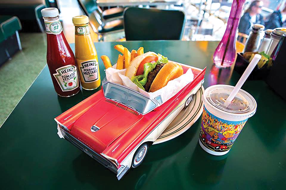 Mel's Drive-In, Los Angeles, Estados Unidos Um hambúrguer e batatas fritas se encontram dentro de um minicarro conversível, que funciona como um prato em cima de uma mesa. Do lado direito, um copo de plástico guarda um refrigerante e, à esquerda, há dois potes: um de ketchup e outro de mostarda