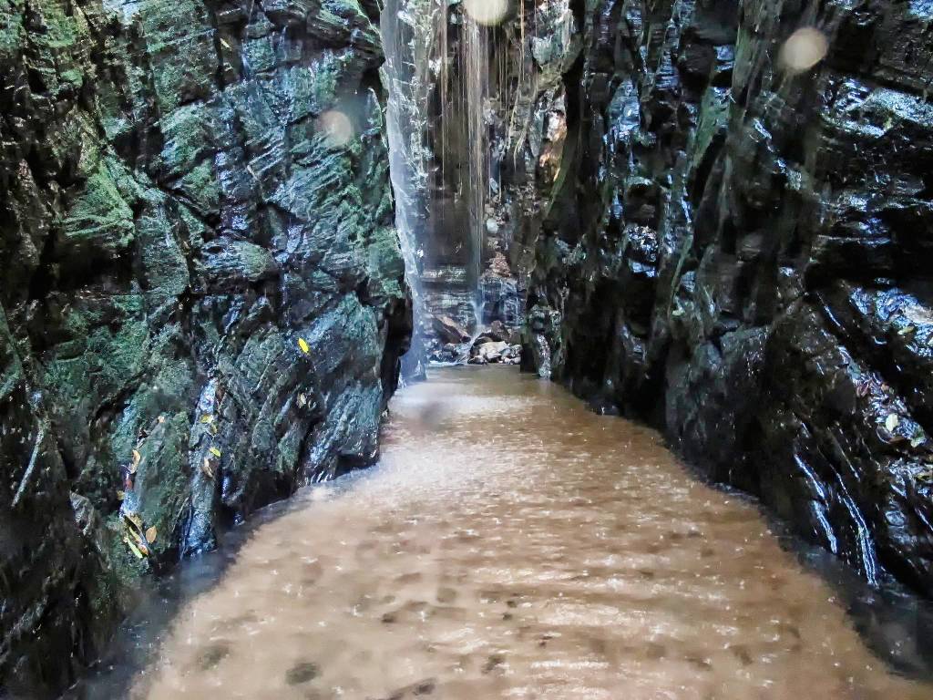 Pedra Caída - Chapada das Mesas Pedra Caída - cachoeira no meio de um cânion de pedras escuras, com corredor coberto de água até os joelhos, na Chapada das Mesas, Maranhão