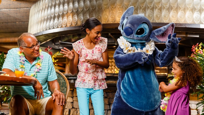 Restaurante Ohana, no Disney's Polynesian Village Resort, Disney, Orlando, Flórida, Estados Unidos Ao lado do pai, duas meninas, uma mais velha e outra mais nova, brincam de dançar a hula junto com o personagem Stitch
