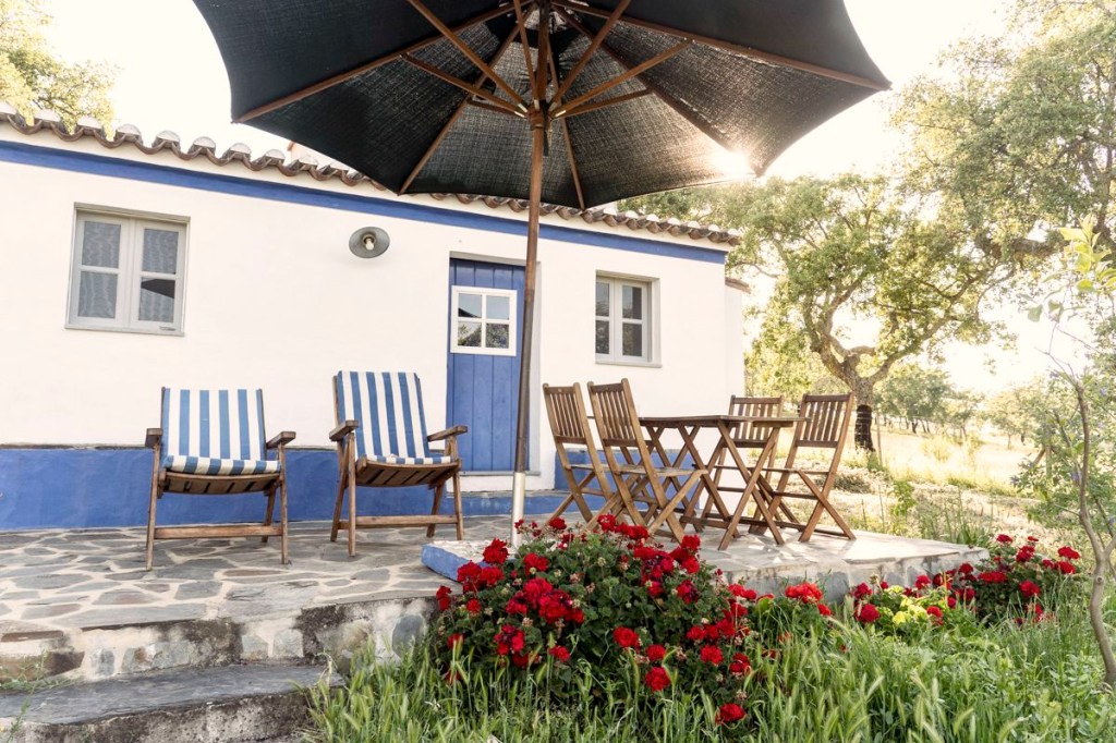 Mesas de madeira e plantas em um terraço do hotel Mama Shelter em Lisboa