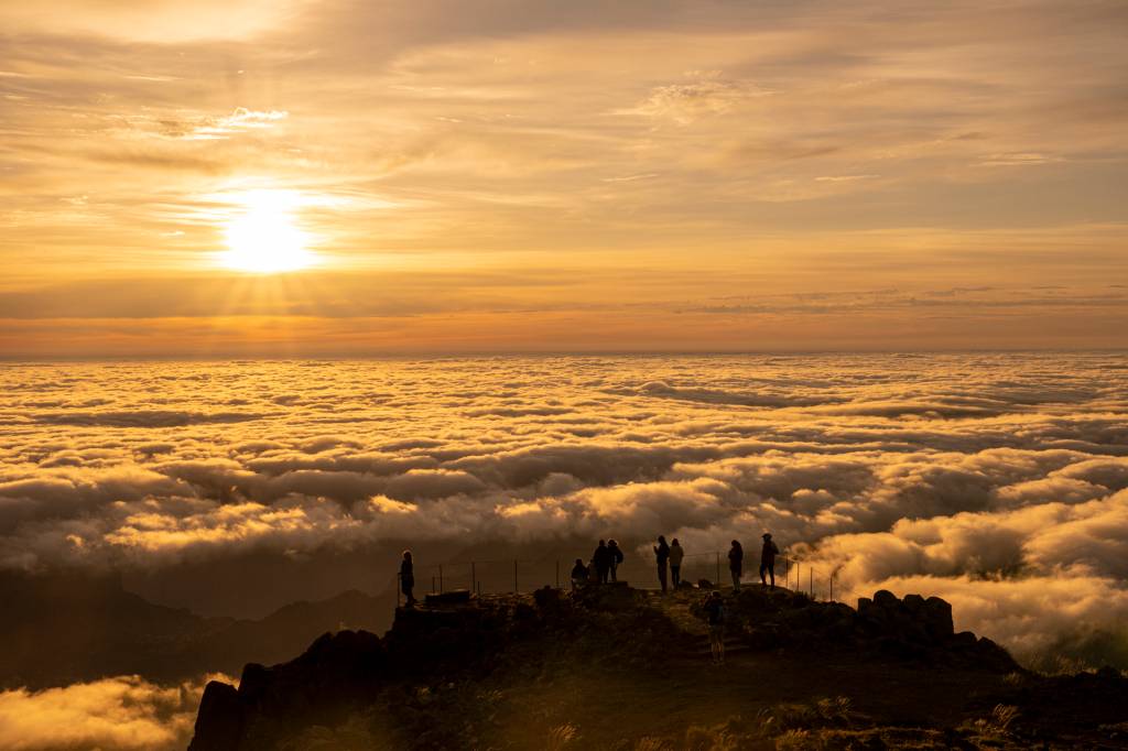 Pessoas assistindo o nascer do sol acima das nuvens no Pico do Areeiro, Ilha da Madeira