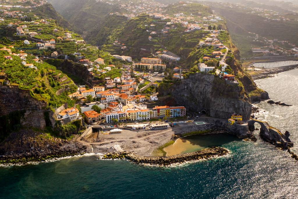 Vista aérea da vila de Ponta do Sol, na Ilha da Madeira, com suas casinhas coloridas à beira-mar