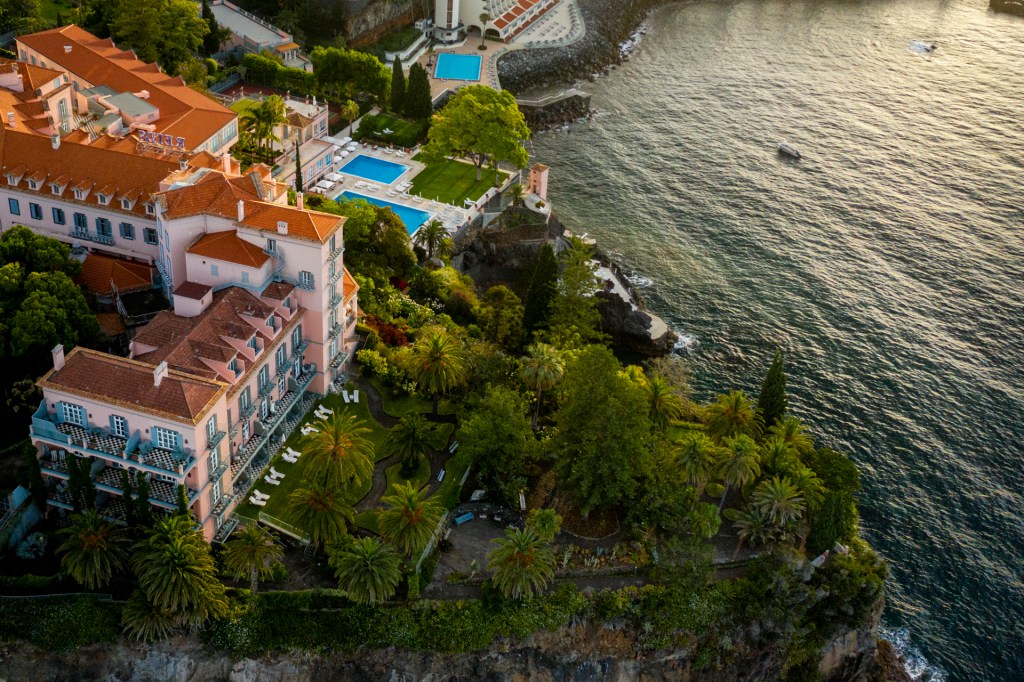 Mesas de madeira e plantas em um terraço do hotel Mama Shelter em Lisboa