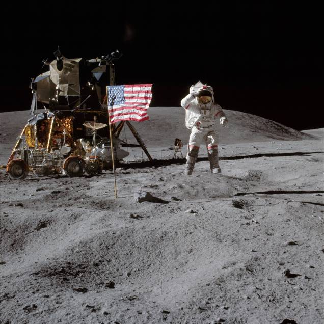 Clássica foto de Neil Armstrong ao lado da bandeira dos Estados Unidos fincada na superfície lunar Clássica foto de Neil Armstrong ao lado da bandeira dos Estados Unidos fincada na superfície lunar