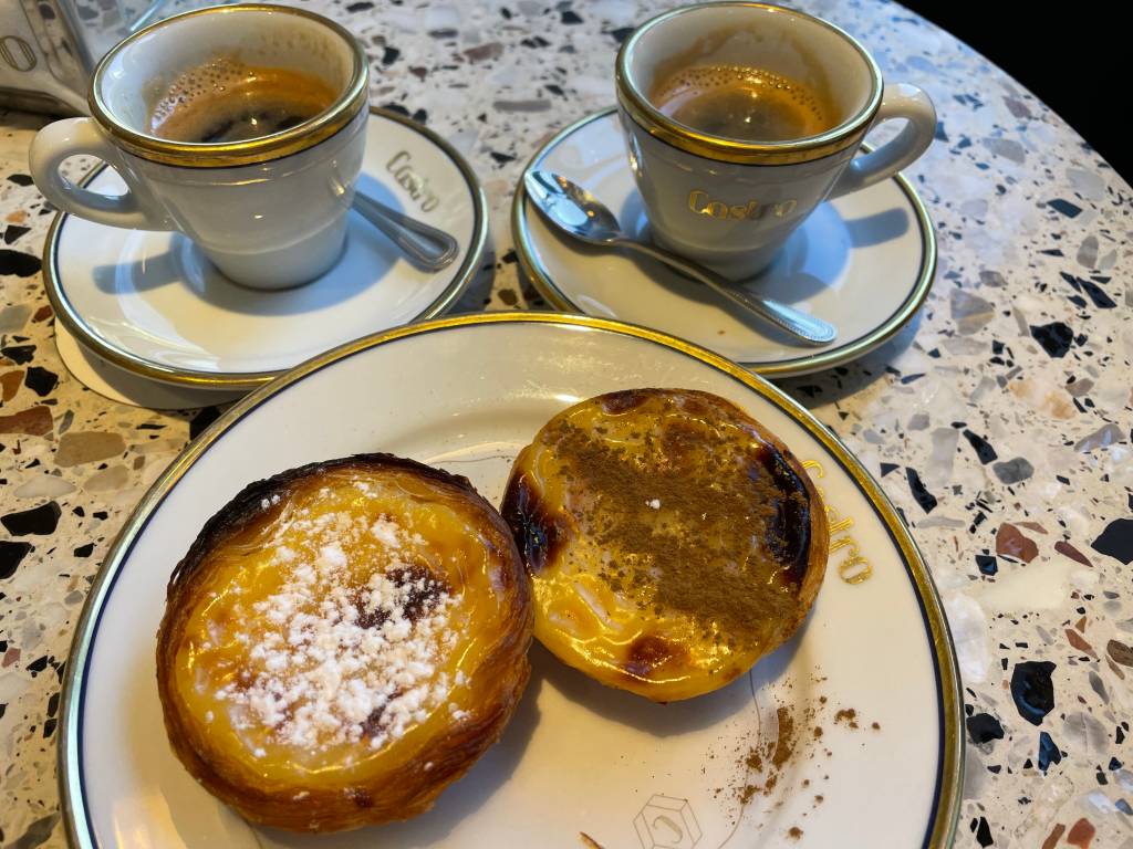 IMG_4231 Dois doces redondos e amarelos, cobertos de açúcar e canela, ao lado de duas xícaras de café