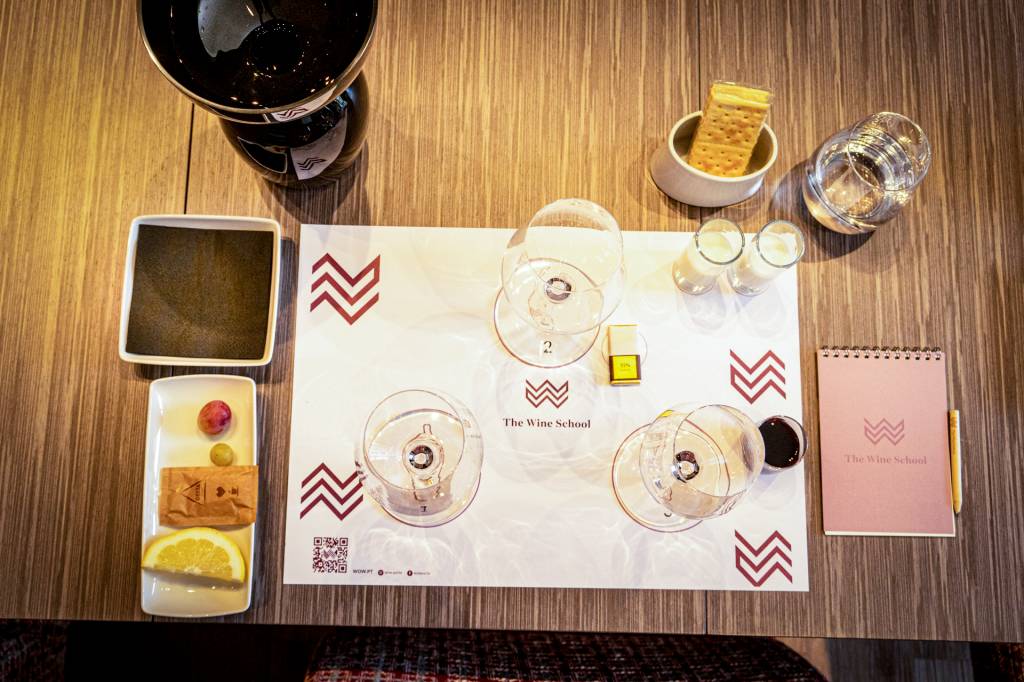 Três copos de vinho e alimentos como leite, manteiga e chocolate para uma aula de degustação de vinhos