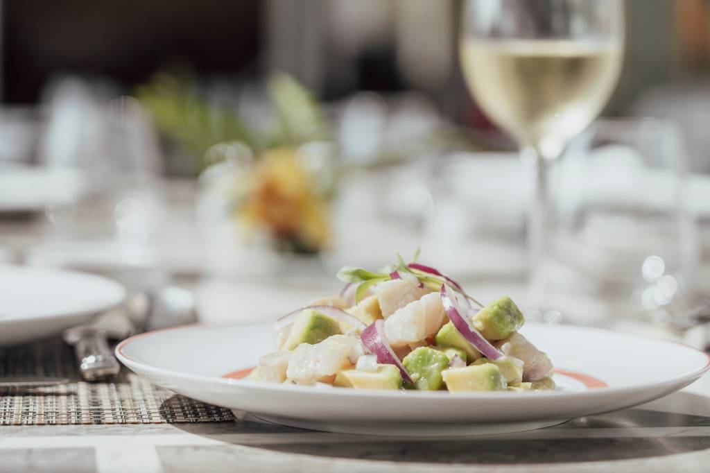 6 Prato de ceviche com uma taça de vinho branco ao lado