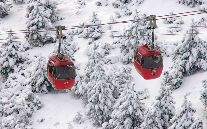Pessoas descendo o morro de neve de trenó